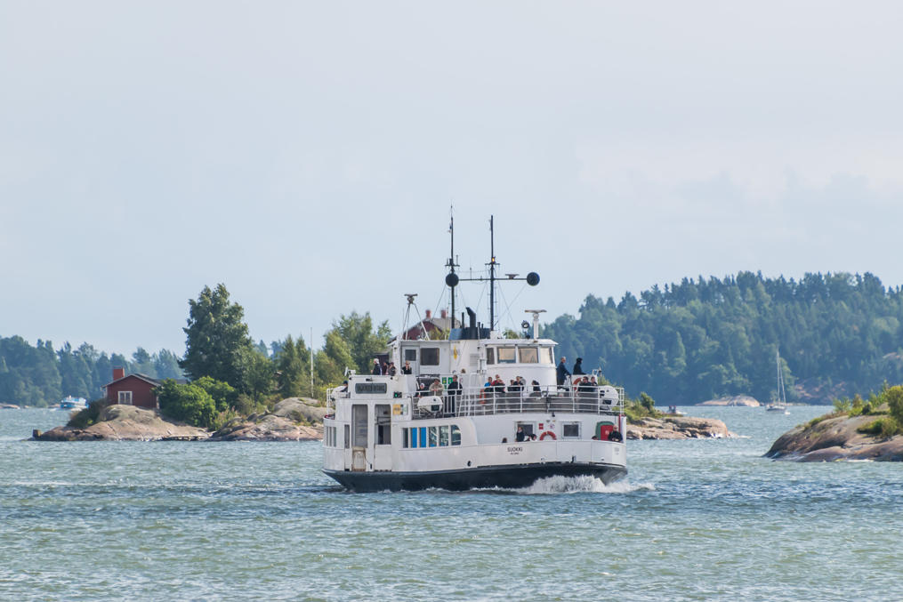 Ferry at sea against islands of Helsinki archipelago