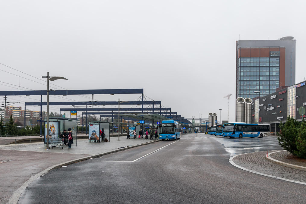 Bus terminal in Leppävaara, Espoo.  Immediately to the left is a railway station platform.  To the right is a major Sello shopping and community center